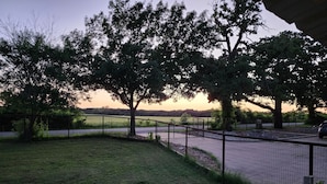 A fenced outdoor area with trees and a paved path. - Country Living located Mid-Way between Granbury and Glen Rose.  (Granbury)