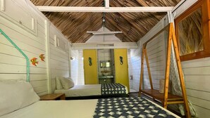 A compact room with a bed, a wooden ladder, and a small table. - HOTEL LAS CASITAS DE MAR ADENTRO  (Rosario Islands)