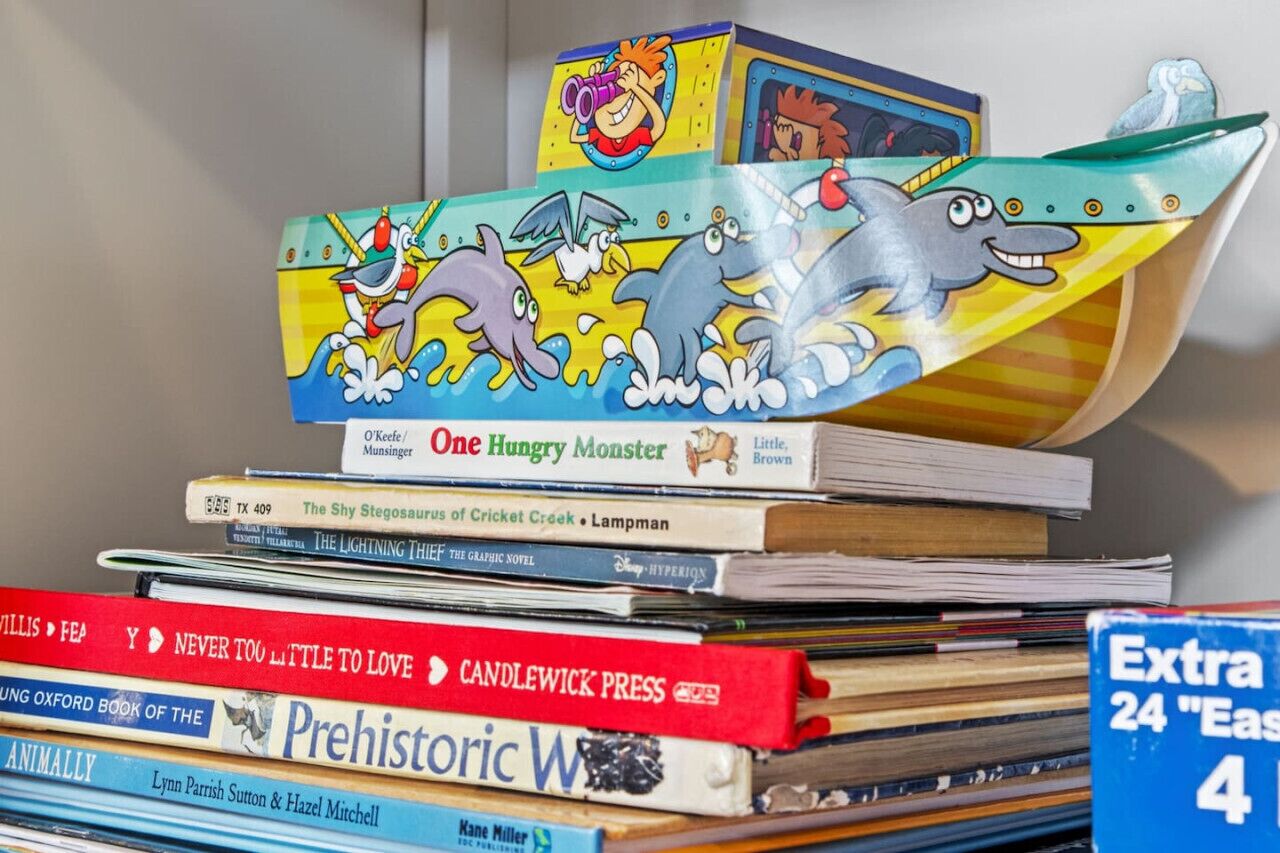 Een stapel boeken met een doos met de tekst 'One Hungry Monster' erboven.