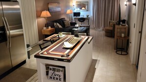 Una cocina moderna con una isla central, un refrigerador y un comedor con mesa y sillas.
