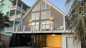 Ein zweistöckiges Haus mit Balkon, Garage und einer Terrasse.
