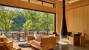 Ein modernes Interieur mit einem großen Fenster, Holzmöbeln und einem Kamin.