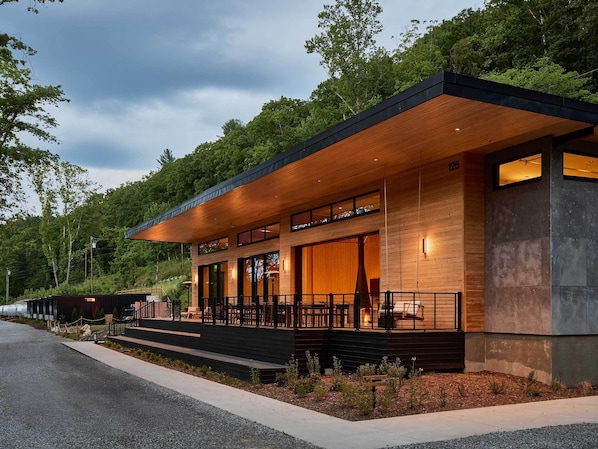 A modern building with a covered outdoor seating area, large windows, and a number '125' sign.