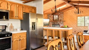 A modern kitchen with wooden cabinets, a stainless steel refrigerator, and a built-in oven.