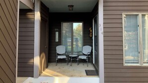 A porch with two chairs and a small table, a welcome sign, and a number '314' on the house.