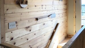 A wooden interior with a sloped ceiling, a hanging light fixture, and a wooden railing. - Hot tub-petfriendly-firepit-pool table-bar-3+acres (McHenry)