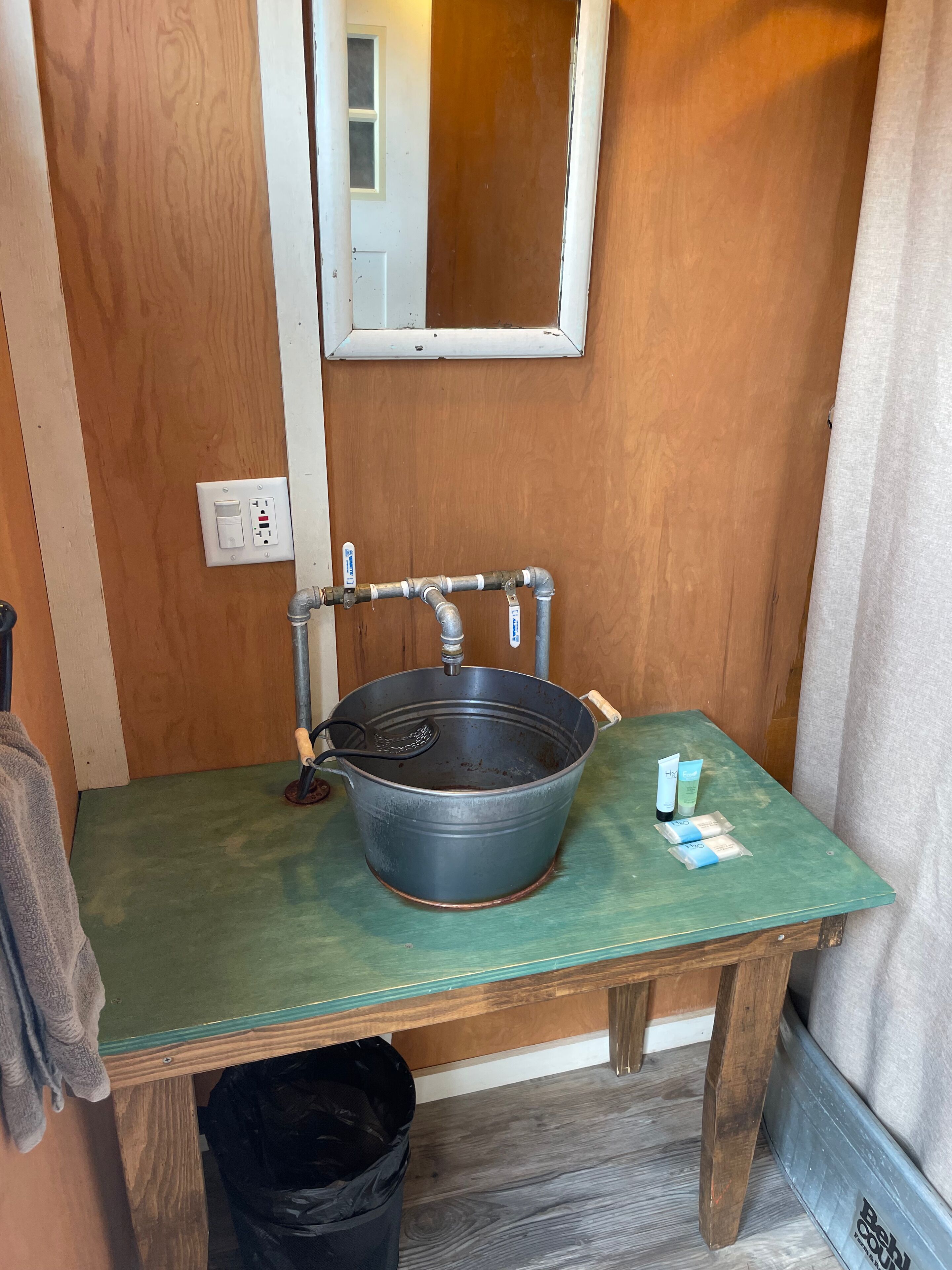 A small bathroom with a wooden vanity, a sink, and a mirror.