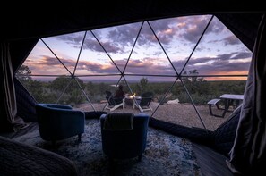 A cozy tent with a view of a sunset over a forested landscape. - Canyonlands Dome Resort (Monticello)