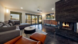 Una sala de estar moderna con chimenea, un sofá modular y un ventanal con vistas panorámicas.