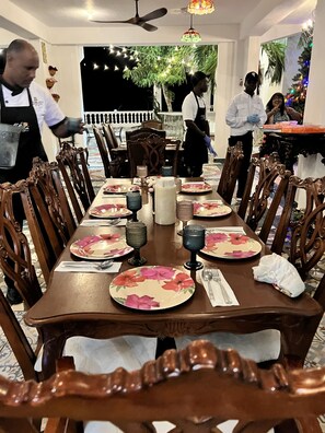 A dining area with a long table set for multiple guests, surrounded by wooden chairs. - Casablanca Hotel (Cabrera)
