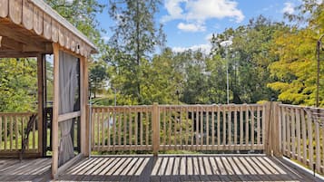 Enjoy a serene forest view from this deck with a covered seating area.