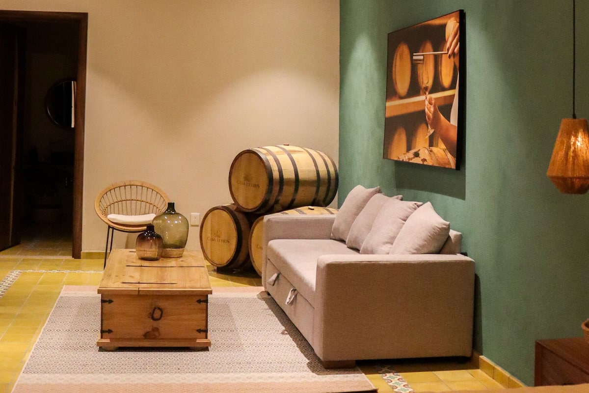 A cozy living room with a sofa, a wooden coffee table, and a hanging lamp.