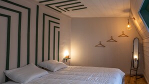 Una camera da letto con due letti, uno specchio e un lampadario.