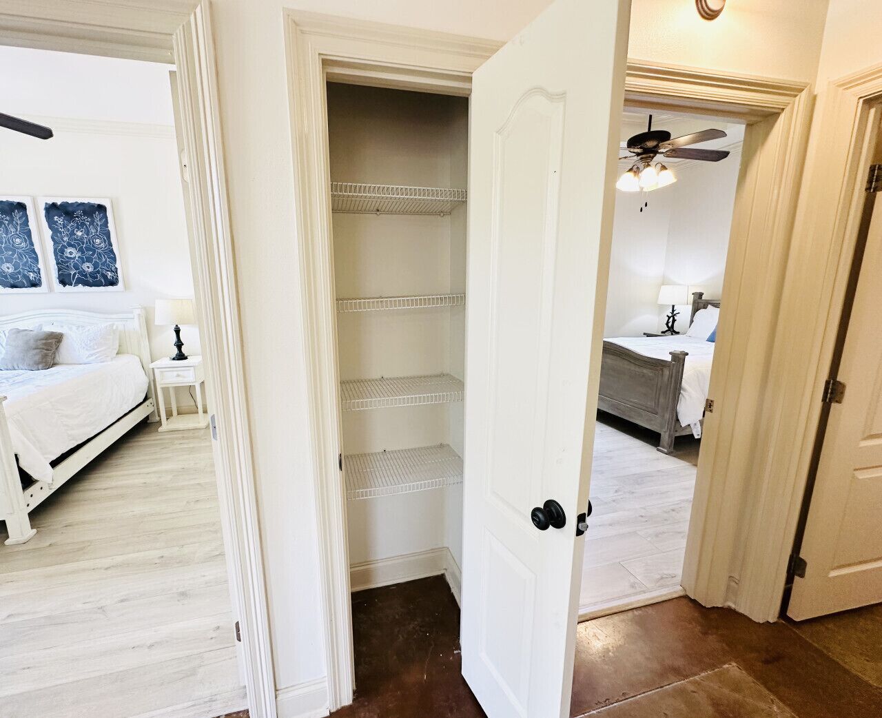 Ein Schlafzimmer mit Bett, Nachttisch und begehbarem Kleiderschrank mit Regalen.