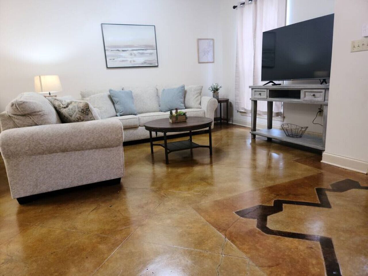 Una sala de estar con un sofá, una mesa de centro y un televisor de pantalla plana.