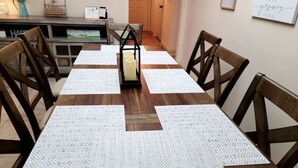 Una mesa de comedor con un camino de mesa de estampado geométrico, sillas de madera y un centro de mesa con velas.