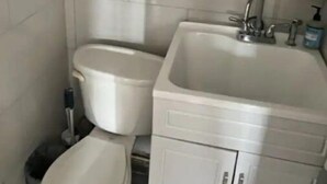 Une salle de bain comprenant des toilettes, un bidet et un lavabo avec un miroir au-dessus.