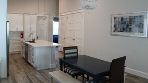 A modern kitchen with white cabinetry, a central island, and pendant lighting. - Delightful 3-bedroom house in Bradenton with WiFi, Games, and more #2 of 2 (Bradenton)