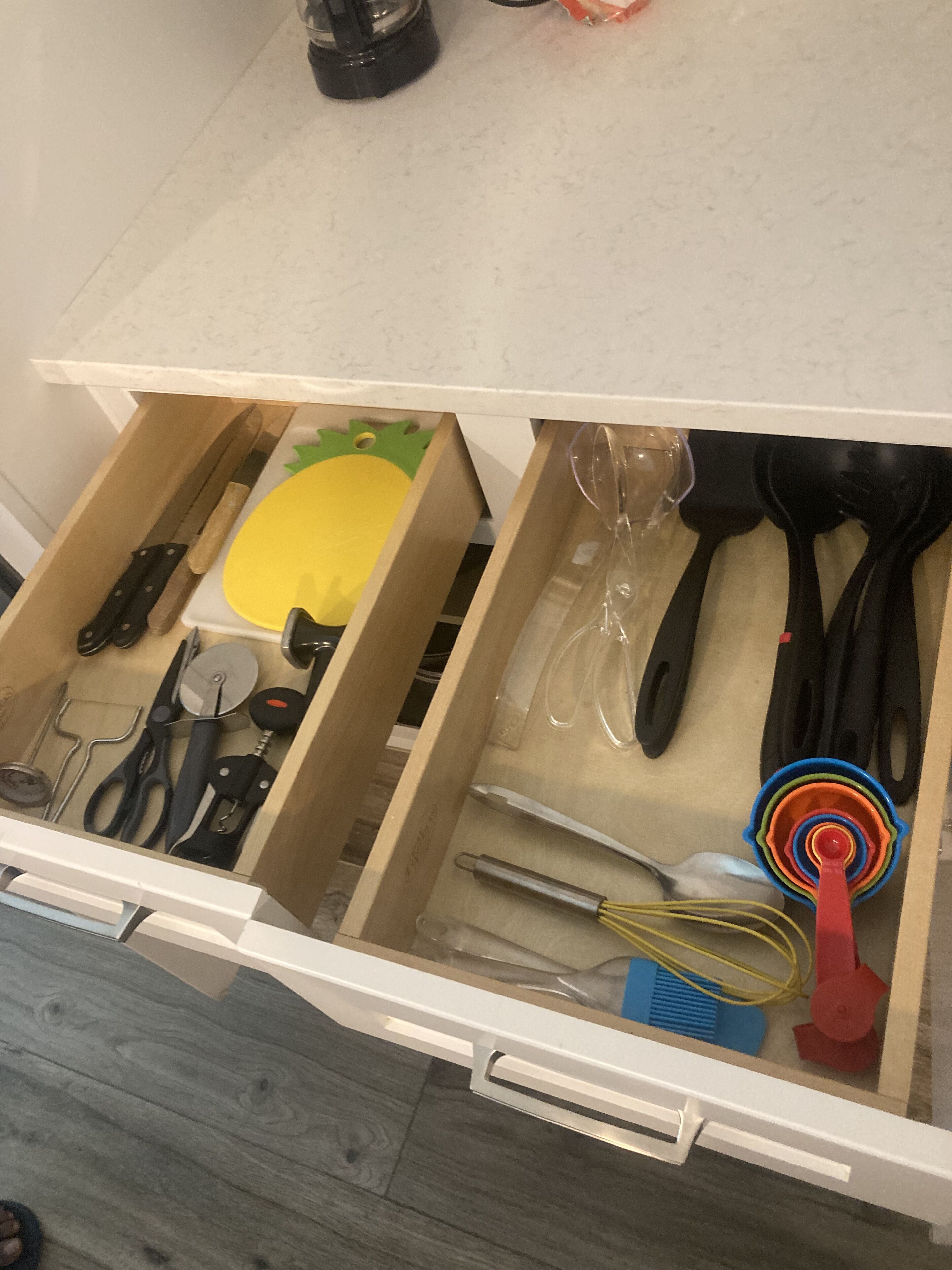A kitchen drawer with various utensils and kitchen tools.