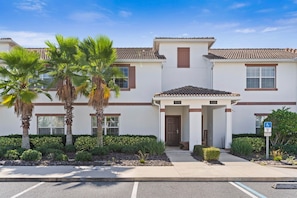A two-story building with a white facade, brown trim, and a tiled roof. - 1590 Moon Valley Drive (Davenport)