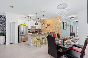 A modern kitchen with a central island, stainless steel appliances, and pendant lighting. - 2452 Reading Trail (Kissimmee)