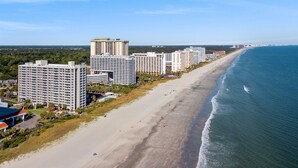 Eine Küstenstadt mit Hochhotels entlang eines Sandstrandes.