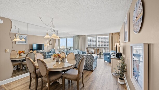 Ein modernes Wohnzimmer mit Essbereich, großen Fenstern und Blick auf die Stadt.