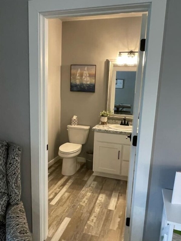 Un baño con inodoro, lavamanos y espejo.