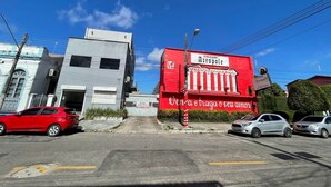 A street view with a red building labeled 'Pousada Acropole' and a grey building. - Pousada Acrópole (Belém)