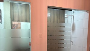 A room with a wooden floor, a glass partition, and a white door. - Pousada Acrópole (Belém)