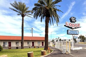 A motel with a red roof, palm trees, and a sign for Del Rio Lodge. - Del Rio Hotel O near Mesa Downtown (Mesa)