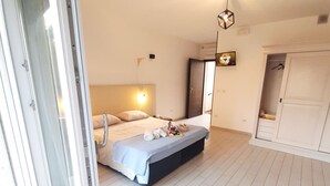 A bedroom with a bed, a bedside table, a wardrobe, and a door leading to another room. - MANSIONS CENTER LECCE 1 (LECCE)