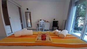 Een hotelkamer met een bed, een bureau, een stoel en een raam met uitzicht op bomen.