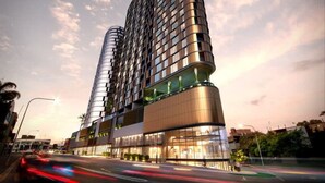 A modern high-rise building with a curved facade, multiple balconies, and a glass exterior.