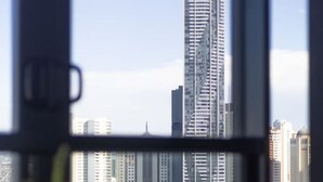 A view from a window overlooking a cityscape with modern high-rise buildings.