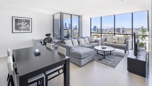 Un salon moderne avec un coin repas, de grandes fenêtres et une vue sur la ville.