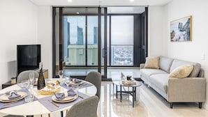 Un salon moderne comprenant un coin repas, un canapé et un téléviseur.
