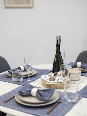 A table set with plates, glasses, a bottle, and a wooden centerpiece.