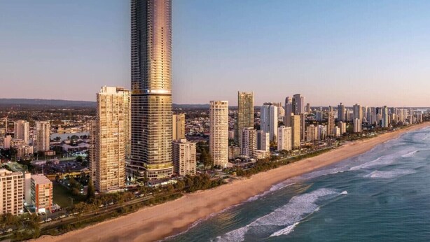 Un paysage urbain côtier avec de hauts immeubles, une plage et un ciel dégagé.