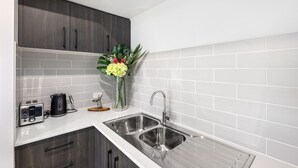 A modern kitchen with white subway tiles, stainless steel appliances, and dark wood cabinets.