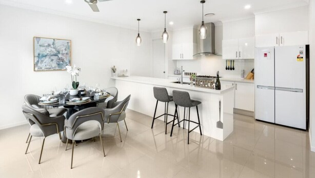 A modern kitchen with white cabinets, a central island, and pendant lighting. - 4BR Cozy house 5mins to beach (Surfers Paradise)