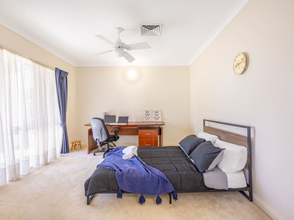 Ein Schlafzimmer mit einem Bett, einem Schreibtisch und einem Stuhl.