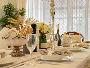 A formal dining table set with a bottle of Moët & Chandon champagne, a bowl of flowers, and wine glasses. - Private Cinema! 5Beds Spacious Villa Near Shops (Calamvale)