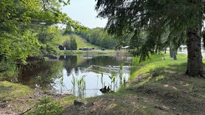 A serene lakeside setting with a dock, trees, and a small building in the background. - The Willowbrook Village at Lake Harmony, a Wyndham Hotel (Lake Harmony)