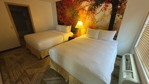 A hotel room with two beds, a nightstand with a lamp, a wall mural, and a radiator. - The Willowbrook Village at Lake Harmony, a Wyndham Hotel (Lake Harmony)
