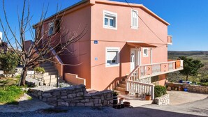 A two-story house with a stone staircase leading to the entrance, a balcony with white balustrades, and a clear view of the surrounding landscape. - Nice apartment in Stara Vas with WiFi (Stara Vas)