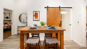 A dining area with a wooden table set for two, a sliding door, and a mirror on the wall. - Venue View: Midtown Bozeman (Bozeman)