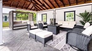 Une terrasse extérieure avec des meubles en osier et un ventilateur de plafond.