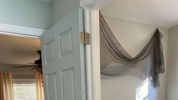 A bedroom with a bed, a bathroom with a bathtub, and a door leading to another room.
