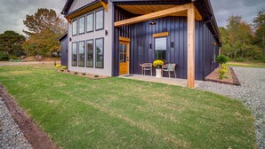Une maison moderne à deux étages, dotée d’un porche abrité, de grandes fenêtres et d’une pelouse bien entretenue.